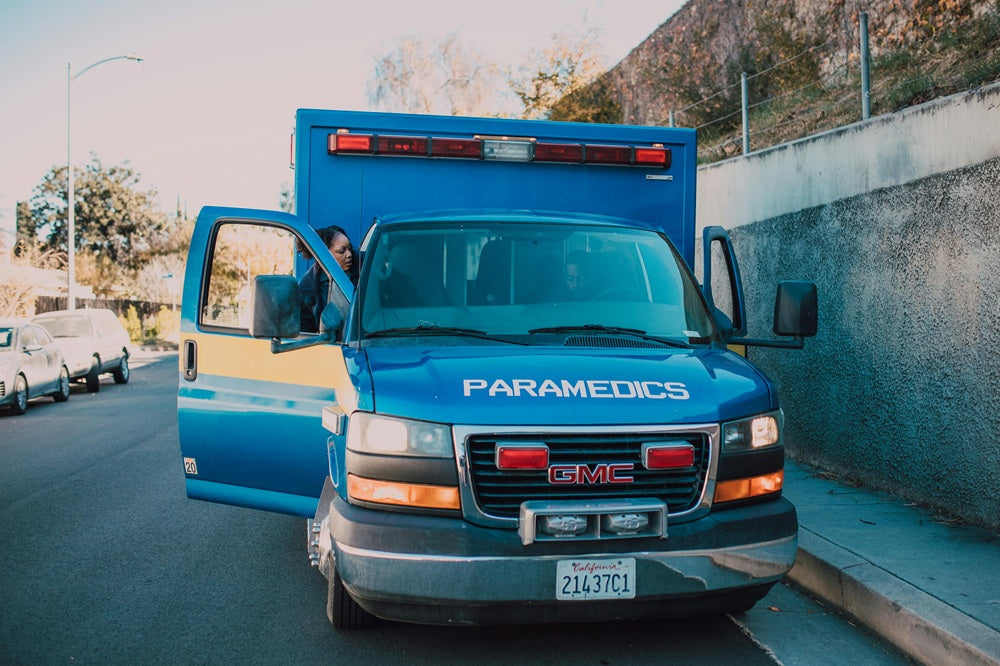Image of a blue ambulance from the front with the door open 