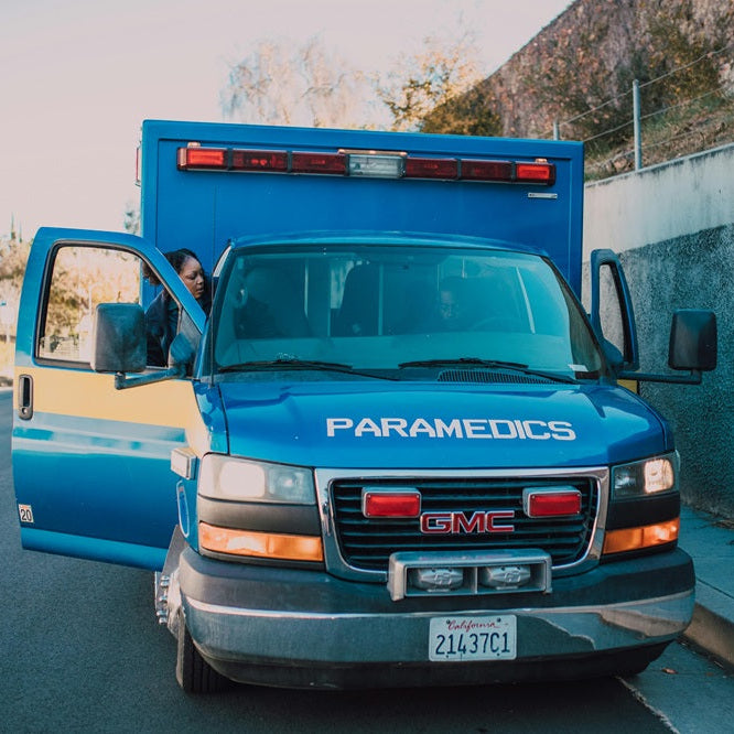 Image of a blue ambulance from the front with the door open 