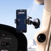 A smartphone running an aviation navigation app is held in place on an aircraft windshield by the SkyHold™ Windshield Suction Phone Mount, with cockpit instruments and a clear sky seen in the background.