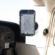 A tablet showing a detailed aviation map is secured with the SkyHold™ Windshield Tablet Mount in a light aircraft cockpit, positioned near switches and controls, as sunlight streams through the window.