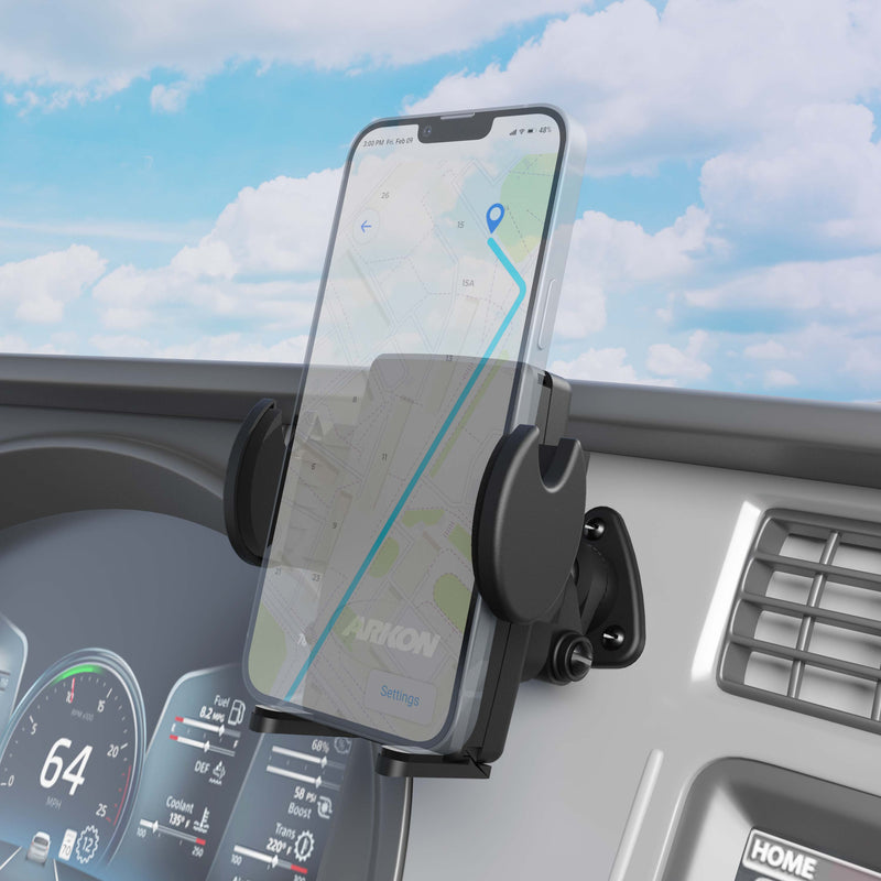 A smartphone with a navigation map is mounted on the car dashboard using the Mega Grip™ Holder with Adhesive Mount. The speedometer reads 64 mph, and a partly cloudy sky can be seen outside.