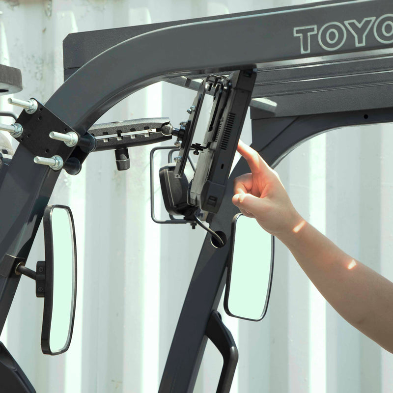 A person installs a 10.25 inch Metal Robust Forklift Front Guard VESA Mount on a Toyota forklift frame, with mirrors and metal supports visible in the background.