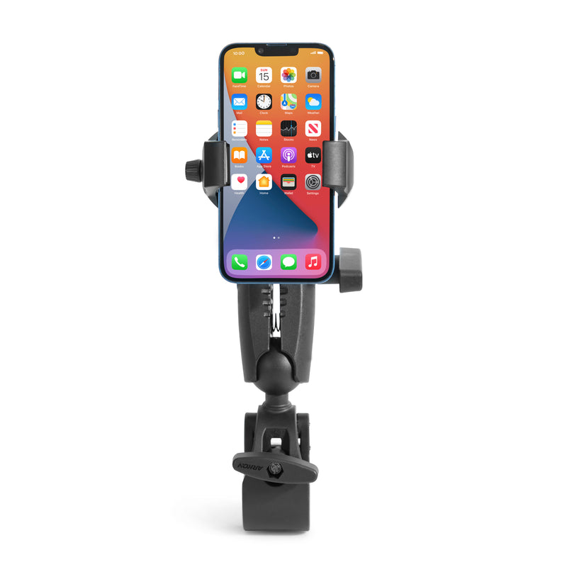 A RoadVise® Ultra Phone and Tablet Holder with Clamp Mount and 5.75” Shaft Arm secures a smartphone in its adjustable black clamp and sturdy base against a white background, the phone showing its home screen with app icons and widgets.