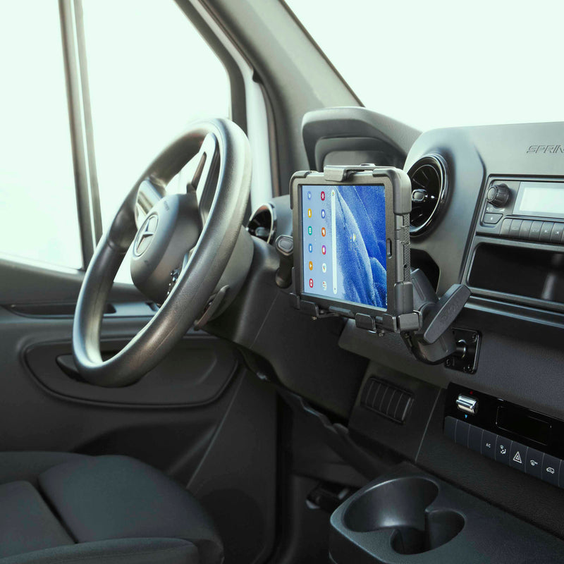 A LockVise™ Metal Locking Tablet Mount with Drill Base is attached to a van dashboard with a Mercedes-Benz logo visible; the tablet displays app icons, highlighting security and convenience within the vehicle interior.