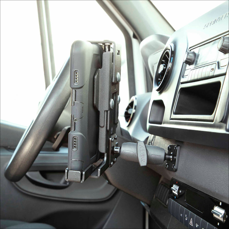 A LockVise™ Metal XL Locking Tablet Holder with Drill Base Mount secures a rugged tablet to the dashboard near the steering wheel and air vent, with control buttons visible below.