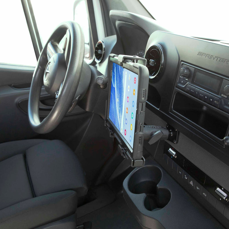 The LockVise™ Metal XL Locking Tablet Holder with Drill Base Mount is securely installed next to the dashboard inside a Mercedes-Benz Sprinter van, showing the steering wheel, cup holders, and control panel.