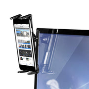 A smartphone is secured in the Adhesive Car Mounting Pedestal - Dual-T Compatible, which is attached to the top edge of a computer monitor and displays a website on the phone’s screen.