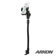 The Car or Truck Seat Rail or Floor Mega Grip™ Phone Holder Mount securely holds an iPhone, Galaxy, or Note with a flexible black gooseneck and clamp base; a map displays on the phone, and the Arkon logo appears in the bottom right corner.
