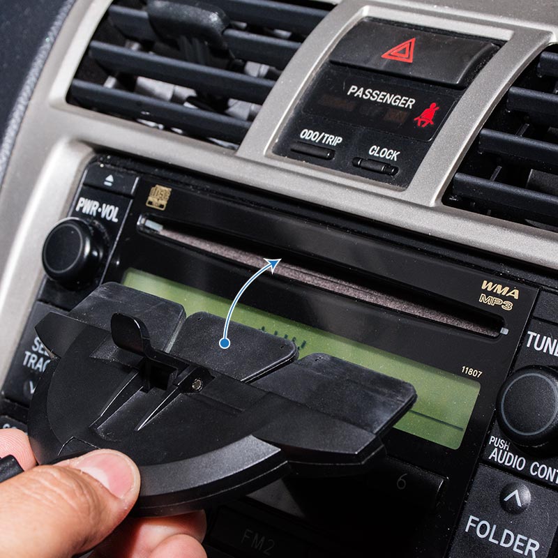 A hand removes the plastic cover from the car stereo slot, revealing a 17mm ball adapter for installing the GPS CD Slot Mount Holder for Garmin GPS.