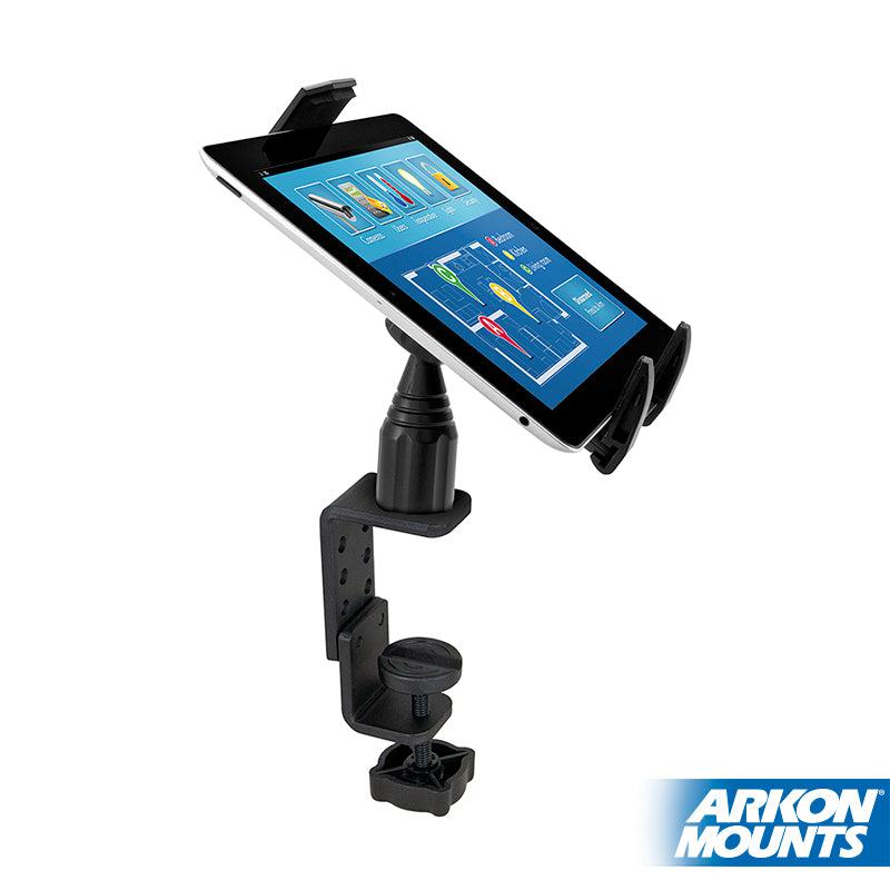 A Heavy-Duty Table or Desk Tablet Clamp Mount with 4 Arm for iPad, Note, and more holds a tablet showing a chart. The mount features a clamp base and is black. The Arkon Mounts logo appears in the bottom right corner.