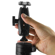 A hand attaches the Heavy-Duty Tripod Mount - Dual-T Compatible to a camera tripod or stand, aligning the threaded connector at the base for secure placement.