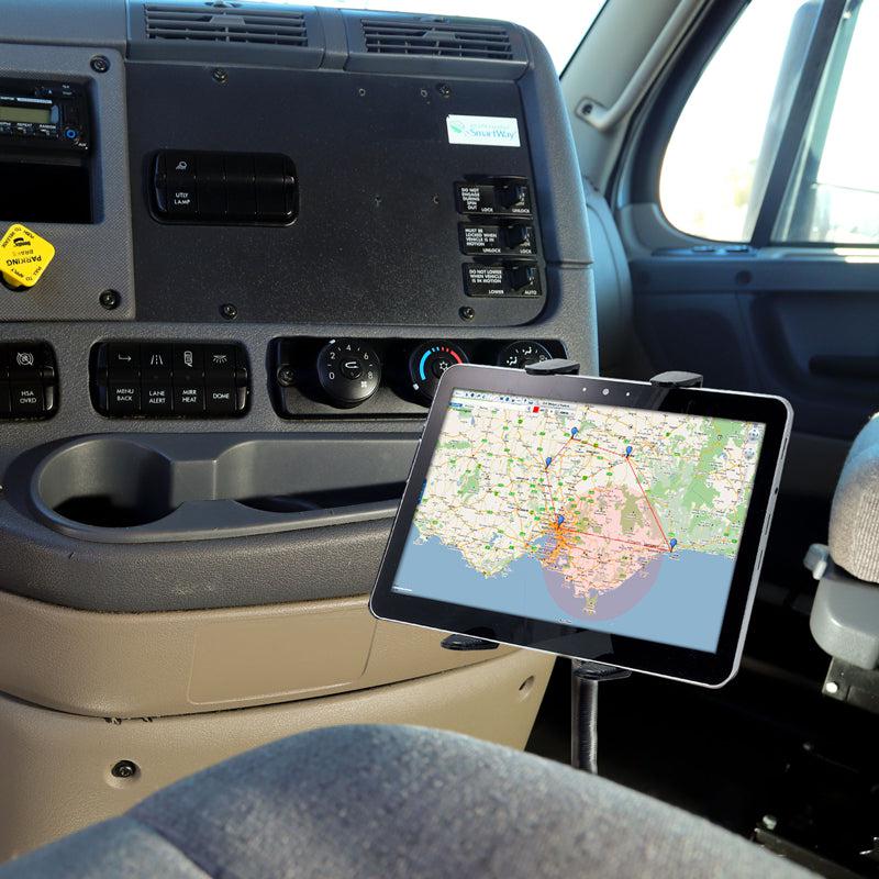 A Heavy-Duty Truck Seat Rail or Floor Slim-Grip® Tablet Mount with 22 inch Arm secures a tablet displaying a map near the drivers seat, close to the dashboard. The cab interior also features control panels, buttons, and a cupholder.