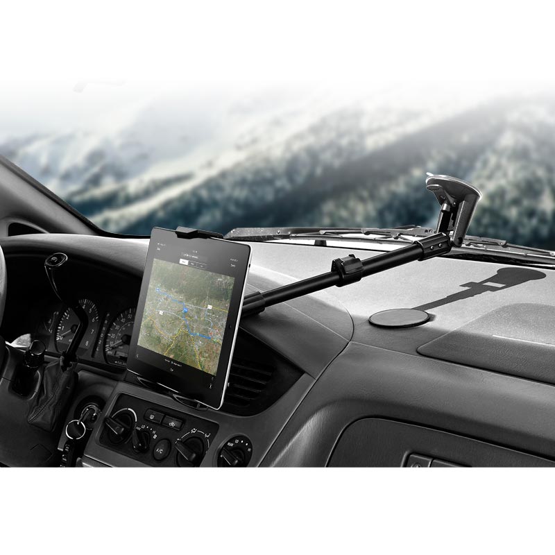 A Long Arm Windshield Suction Tablet Mount for iPad, Note, and more holds a tablet displaying a map navigation app on the dashboard, with the vehicle’s interior and a blurred outdoor landscape visible in the background.