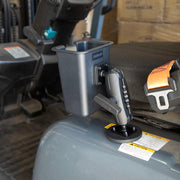 A Magnetic Mount with Barcode Scanner Holster Holder is attached beside the operators seat, near an orange safety seatbelt. Cardboard boxes are stacked in the background.
