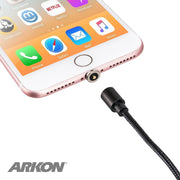 A close-up of a smartphone with the Magnetic USB to Lightning Charge Cable adapter attached, plus a matching iPhone charging cable nearby. The ARKON logo is visible in the lower left corner.