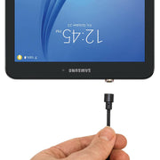 A hand holds a black audio cable near the headphone jack of an upside-down Samsung tablet showing 12:45 PM, next to a Magnetic USB to Micro USB Charge Cable.