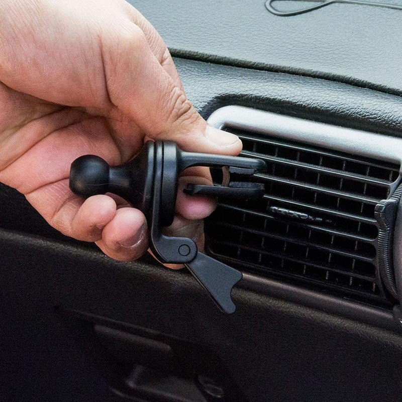 A hand is attaching the Car Vent Mount with Mega Grip™ Holder to a cars air vent.