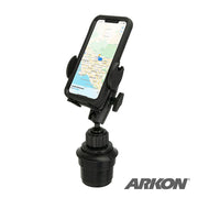 The Mega Grip™ Universal Car Cup Holder Phone Mount holds a smartphone with maps displayed, providing hands-free navigation. It fits securely in your vehicle’s cup holder; the Arkon logo appears in the bottom right corner.