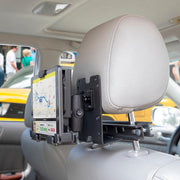 A LockVise™ Metal Locking Car Headrest Tablet Mount with 2.75 Shaft holds a tablet displaying a navigation map, viewed from the back seat with the car interior and people visible outside the window.