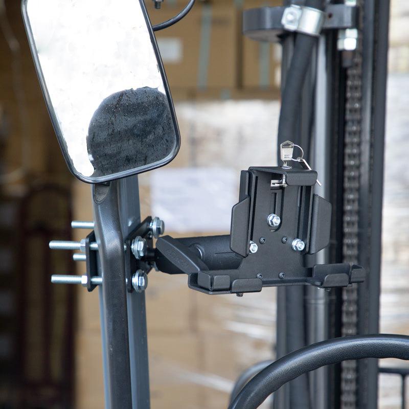 A close-up of the LockVise™ Metal Locking Forklift Front Guard Tablet Mount with a secure mechanism and 5 Metal Robust™ Shaft, attached to a vertical post near a rectangular mirror.