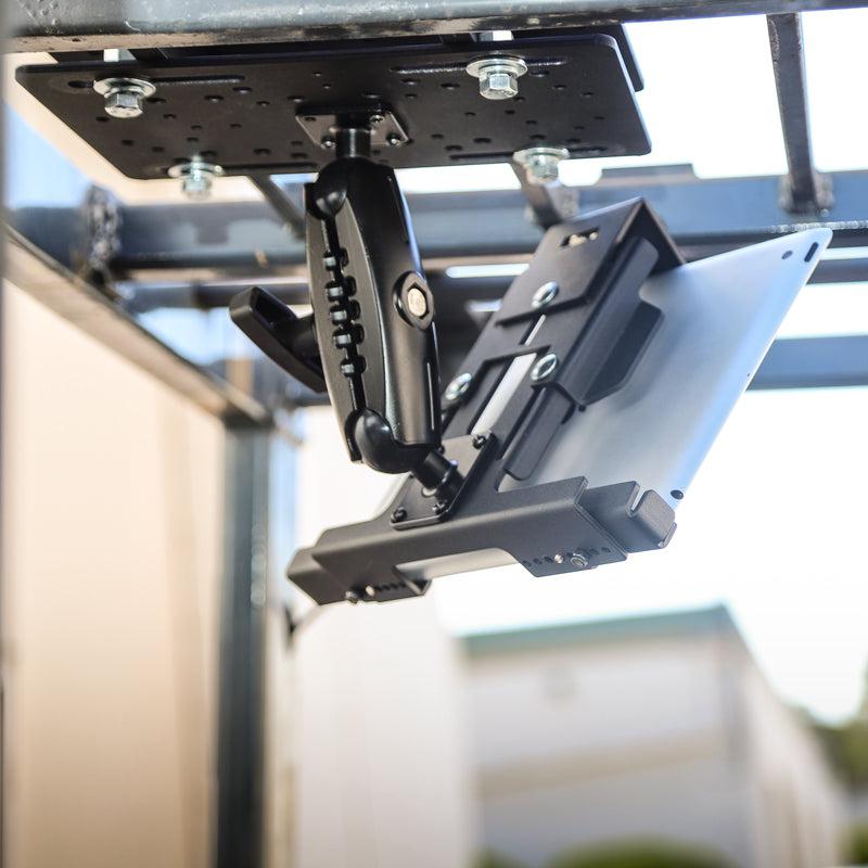 Close-up of the LockVise™ Metal Locking Forklift Overhead Guard Tablet Mount with 5 Metal Robust™ Shaft securely holding a tablet on a metal frame outdoors, with blurred buildings in the background.