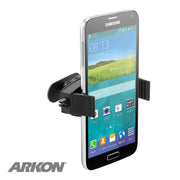 A Samsung phone is secured in the black Mobile Grip 2 Adhesive Phone Car Mount for iPhone, Galaxy, Note, and more on a car vent. The phone displays a weather widget and app icons; the Arkon logo appears in the bottom left corner.