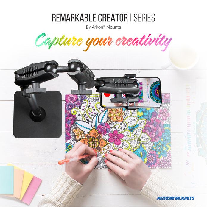 A person colors a detailed floral page as a smartphone records from above using the Remarkable Creator™ Pro+Plus with Pink Extension Pole. Text reads: Remarkable Creator Series: Capture your creativity.