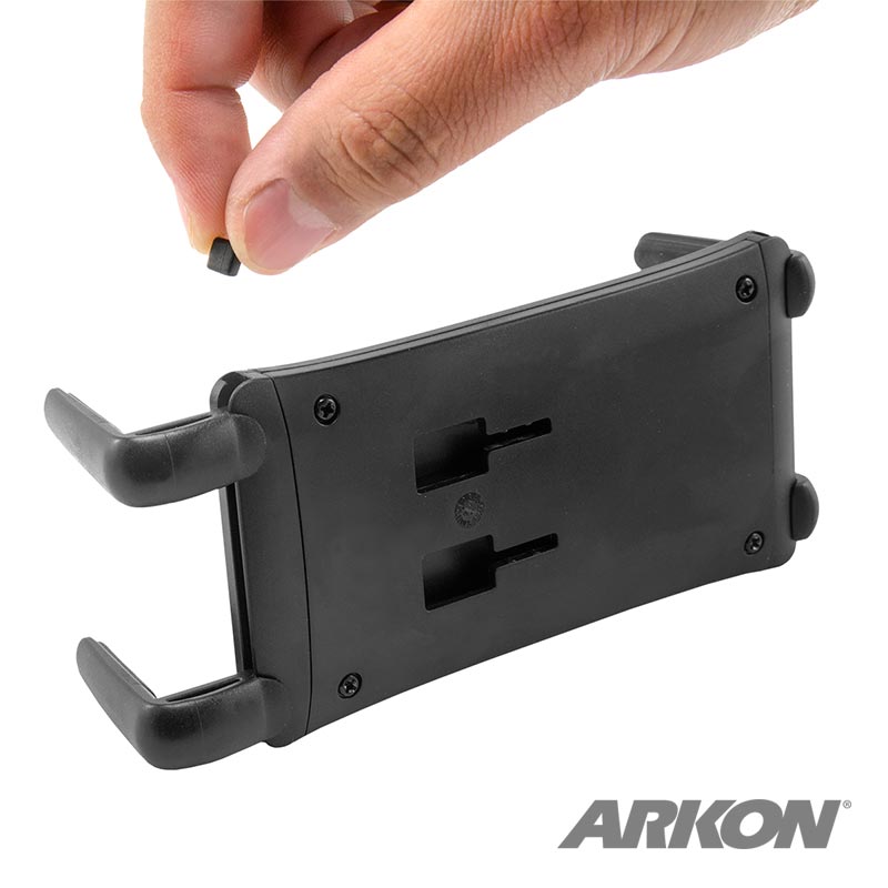 A hand holds a black Replacement Stopper for the Slim-Grip Ultra Smartphone and Midsize Tablet Holder above the holder, with the ARKON logo visible in the bottom right corner.