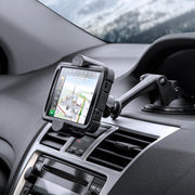 A smartphone is secured on the dashboard with the Sticky Suction Mount and RoadVise® Phone Holder, displaying navigation directions as snowy scenery appears through the windshield in the background.