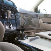 A Heavy-Duty Car Cup Holder VESA Mount is installed near the center console between the driver and passenger seats, with the dashboard, gear shift, and cup holders visible. No tablet is mounted.