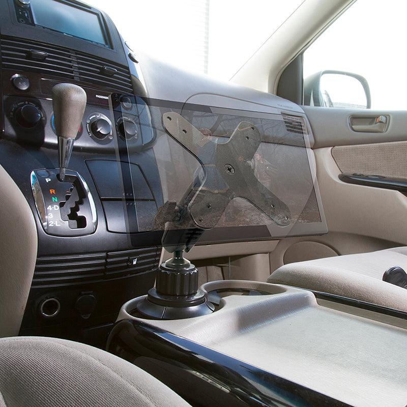 A Heavy-Duty Car Cup Holder VESA Mount is installed near the center console between the driver and passenger seats, with the dashboard, gear shift, and cup holders visible. No tablet is mounted.