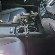 A smartphone is mounted on the LockVise™ Locking Seat Rail Tablet Mount with an 18 aluminum gooseneck, attached to a car’s seat rail between the driver and passenger seats, with the phone facing the driver.