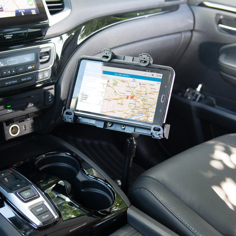 A tablet mounted with the LockVise™ Locking Seat Rail Tablet Mount with 18 Aluminum Gooseneck displays a map next to the driver’s seat, above the center console with cup holders and car controls visible.