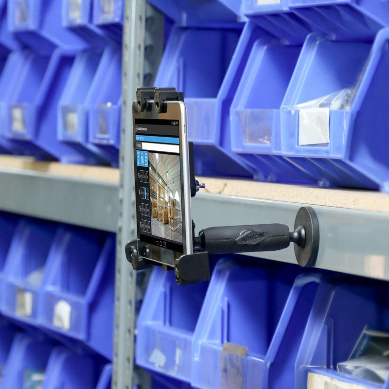 A smartphone is secured on a shelf with the LockVise™ Locking Magnetic Tablet Mount for inventory tasks, surrounded by blue plastic bins filled with small parts.