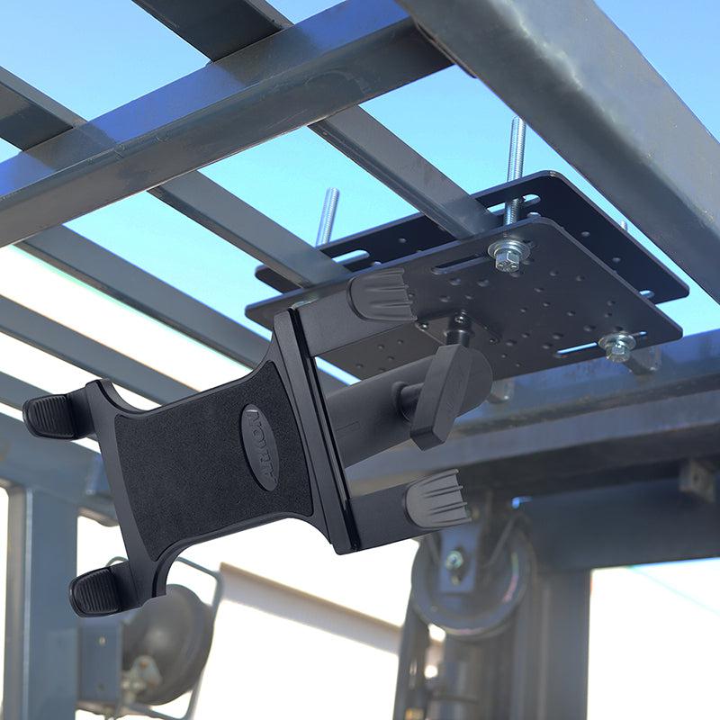 The Slim-Grip® Tablet Holder with Forklift Overhead Guard Mount and 8.5 Metal Shaft is firmly attached to a forklift’s overhead guard, securing a tablet for industrial use under a clear blue sky.