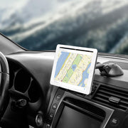 A Slim-Grip® Ultra Sticky Suction Windshield or Dash Phone Car Mount securely holds a tablet displaying a map on a car dashboard, with the steering wheel, controls, and a blurred outdoor scene visible through the windshield.