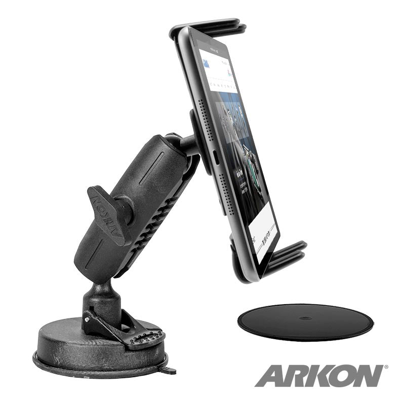 A black Slim-Grip® Ultra Windshield Mount for iPhone, Galaxy, Note, iPad and more with a suction cup base holds a smartphone in portrait. A round adhesive pad is nearby. The Arkon logo appears in the lower right corner.