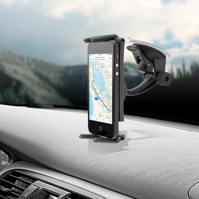 A smartphone showing a map is mounted upright on a car dashboard with the Slim-Grip® Ultra Windshield or Dash Phone Car Mount for iPad, Note, and more; mountains are blurred through the windshield.