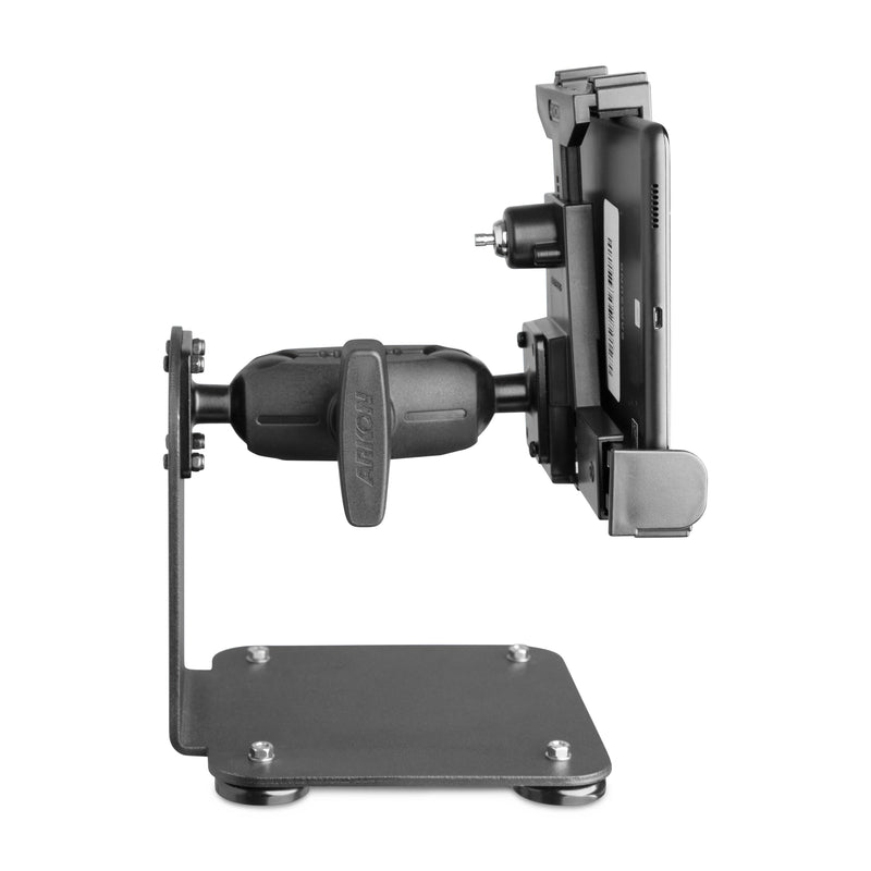 A side view of the SteadyMag™ Magnetic Mount System with LockVise™ Locking Tablet Holder, featuring a sturdy base and adjustable arm, securely holding a handheld electronic device in a warehouse setting.