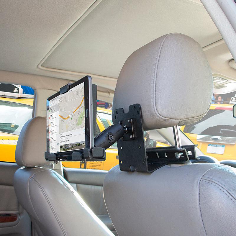 A Taxi Headrest Tablet Mobile Printer Payment Terminal Mount (4-Hole AMPS compatible) holds a tablet on a gray leather car headrest, displaying a map app. Other vehicles can be seen outside the car.