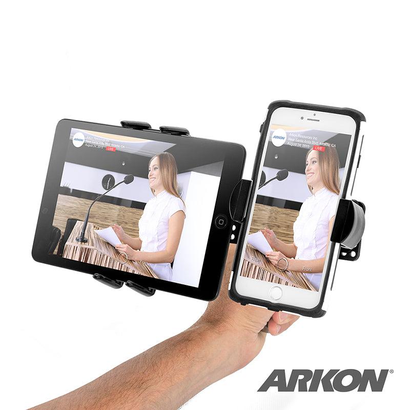 A hand holds the TW Broadcaster Combo—Slim-Grip® Ultra and RoadVise® Phone Tripod Mount Holder for Live Streaming—displaying a tablet and smartphone, both showing the same woman at a podium. The Arkon logo is in the lower right corner.