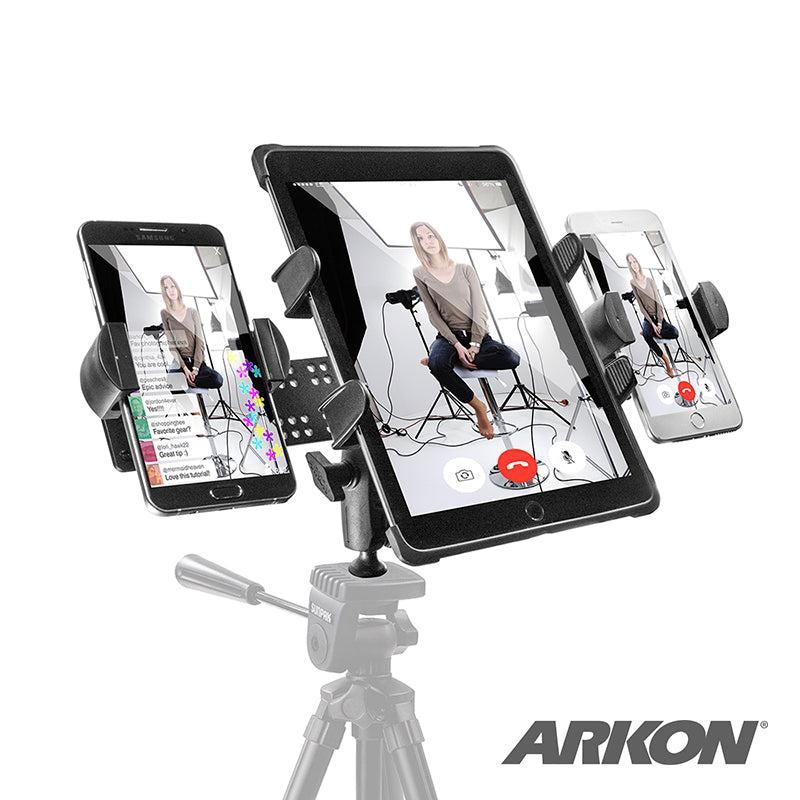 The TW Broadcaster TriStreamer Tripod Adapter for Slim-Grip® Tablet and Dual RoadVise® Phone holds a tablet and two smartphones—all showing a woman in a studio—for dual live streaming. ARKON logo is at the bottom right.