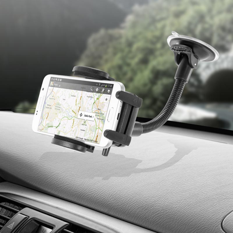 The Windshield Suction Car Mount for iPhone, Galaxy, and Note is attached to the dashboard with a flexible gooseneck, holding a phone that displays map navigation. The blurred windshield background highlights its practical use.